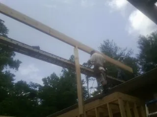 Carpenter setting a ridge beam over a new addition frame — Ice Dam Removal by Roofing Brothers in Crandon