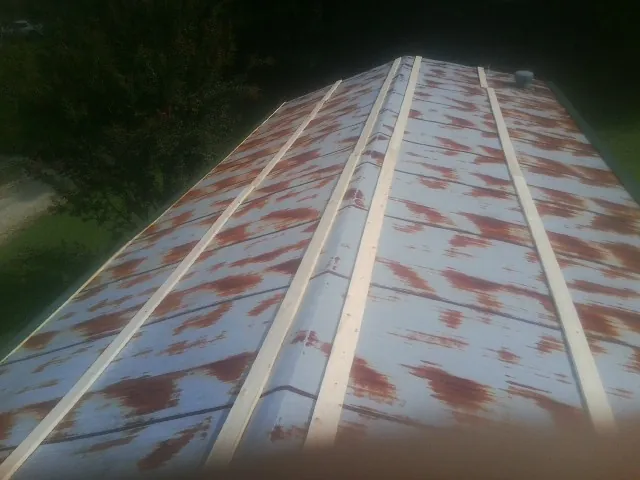 Rusted metal roof panels with new wood purlins before replacement — Storm Damage Roof Repair in Crandon by Roofing Brothers